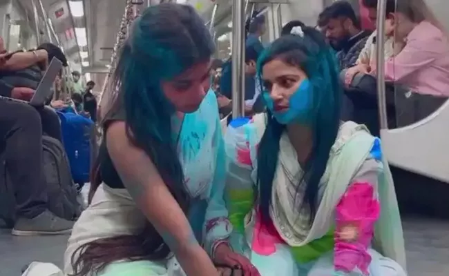 two girls Holi Inside Delhi Metro Sparks Debate On Internet - Sakshi