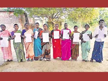 మా భూములు ఇప్పించండంటూ పట్టాలు చూపుతున్న లబ్ధిదారులు - Sakshi