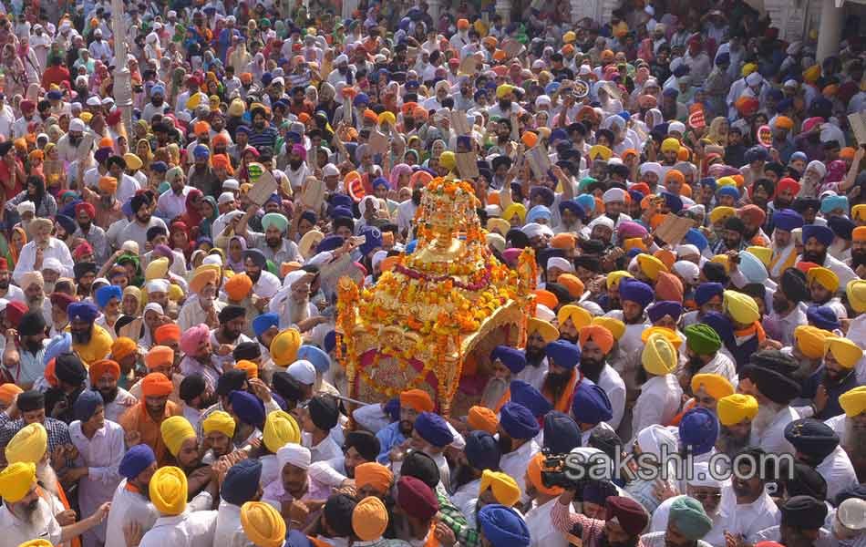 Sikh priest sits behind the Guru Granth Sahib8
