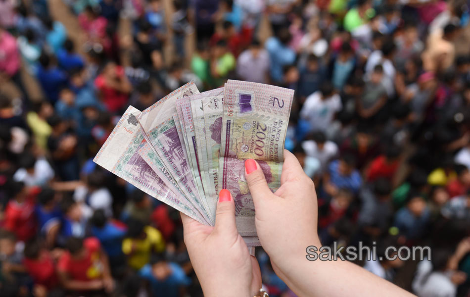 Children jump to catch money thrown by Catholics - Sakshi1