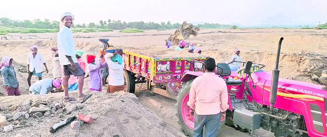 టేకుమట్ల మండలంలోని చలివాగులో ట్రాక్టర్లో ఇసుకను నింపుతున్న కూలీలు1