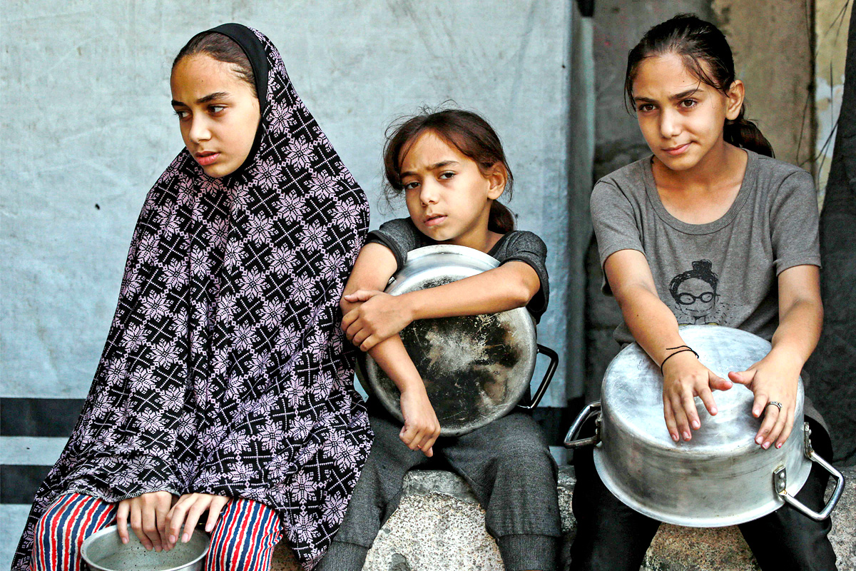 Palestinians wait for donated food at a community kitchen in Gaza City7