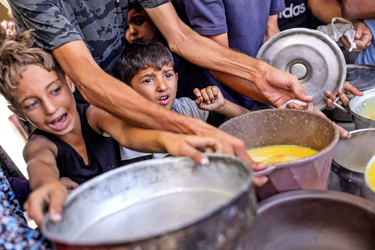 Palestinians wait for donated food at a community kitchen in Gaza City10