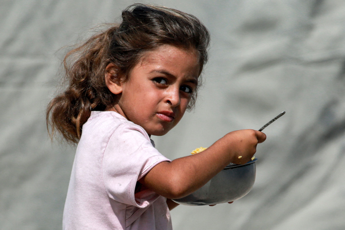 Palestinians wait for donated food at a community kitchen in Gaza City13