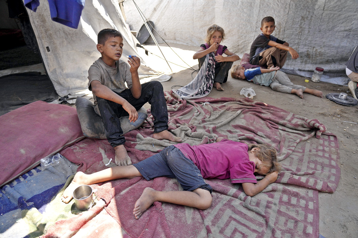 Palestinian boy receives the last drops of lentil soup at a food distribution point in Gaza11