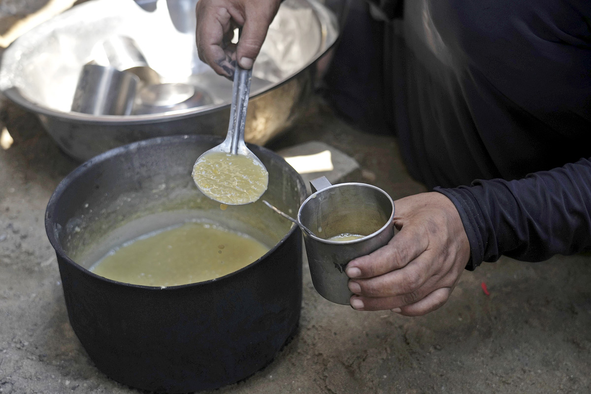 Palestinian boy receives the last drops of lentil soup at a food distribution point in Gaza12