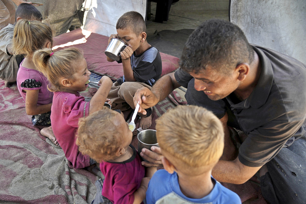 Palestinian boy receives the last drops of lentil soup at a food distribution point in Gaza14