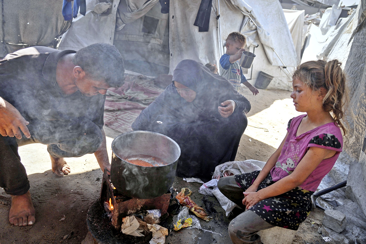 Palestinian boy receives the last drops of lentil soup at a food distribution point in Gaza15