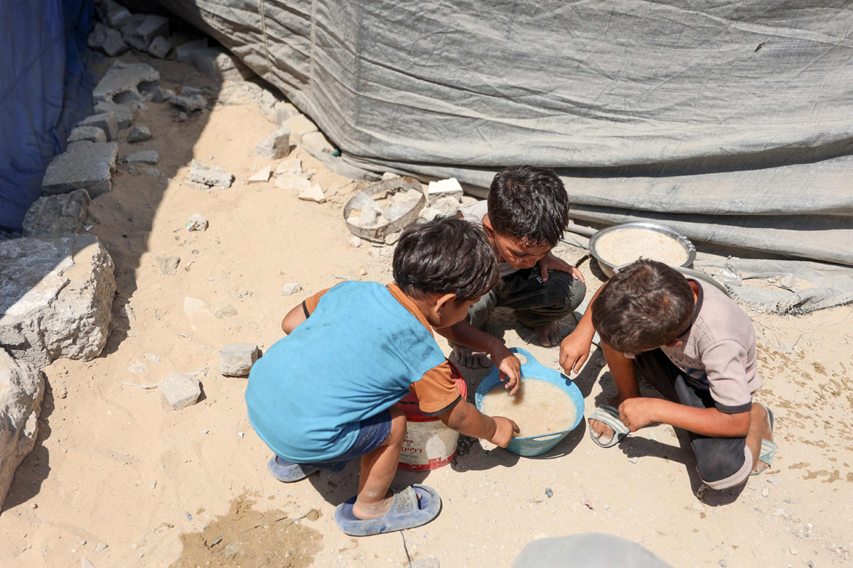 Palestinian boy receives the last drops of lentil soup at a food distribution point in Gaza2