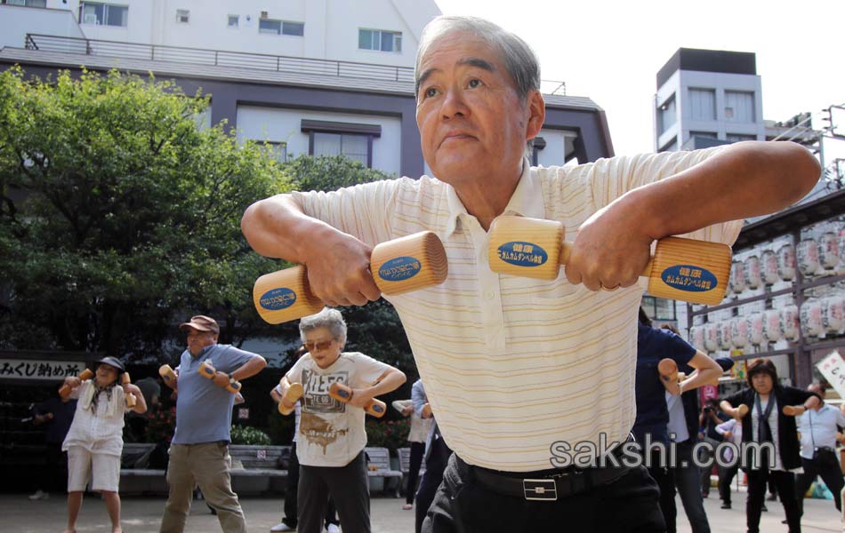 Elderly people work out with wooden dumb bells