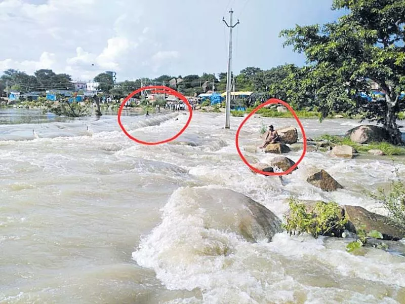 Two young men trapped in Manjira floods - Sakshi