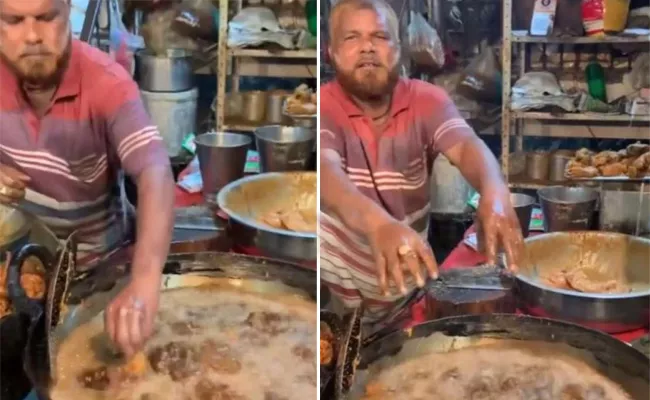 The man puts his bare hands into piping hot oil and pulls out  fried chicken - Sakshi