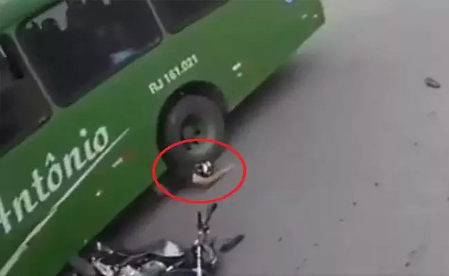 Biker Survive After His Head Comes Under A Bus Tyre With Helmet - Sakshi