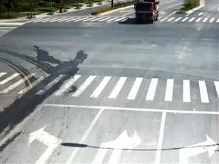 bike skids under truck, rider walks away unhurt