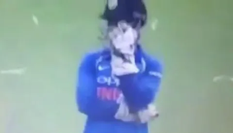 MS Dhoni tries to hide his face