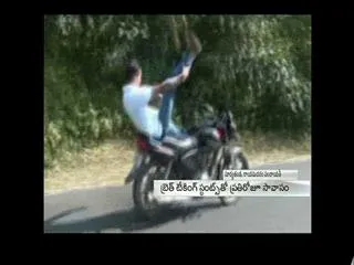 Man performing bike stunts in khammam district - Sakshi