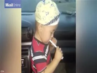 Mother filmed teaching her son, 2,  how to SMOKE until he grimaces and takes the cigarette out of his mouth - Sakshi