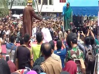 woman canned in indonesia as crowd cheers - Sakshi