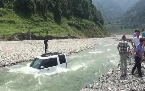 Chinese man washes car in river to save money - Sakshi