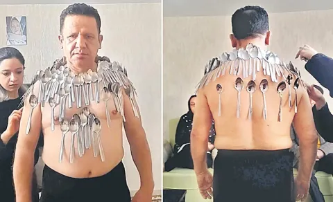 Man balances 96 spoons on body to break own record