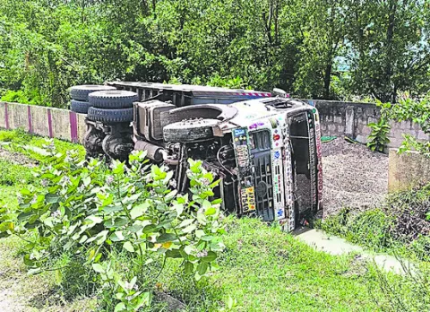 హైవే పక్కన పల్టీ కొట్టిన టిప్పర్‌ 
