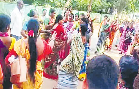 Women farmers pounding for urea in Gajwel