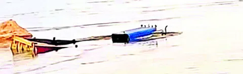 నదిలో ఇరుక్కున్న ఇసుక ట్రాక్టర్‌ 
