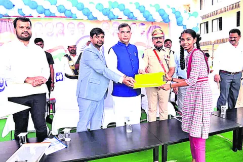  Government Advisor Venugopal Rao and Collector Kumar Deepak handing over the exam pad to a student.