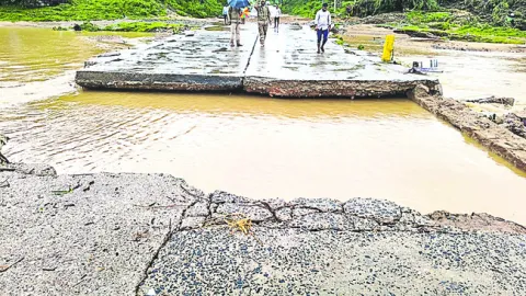 తెగిన బ్రిడ్జి.. కూలిన ఇళ్లు 
