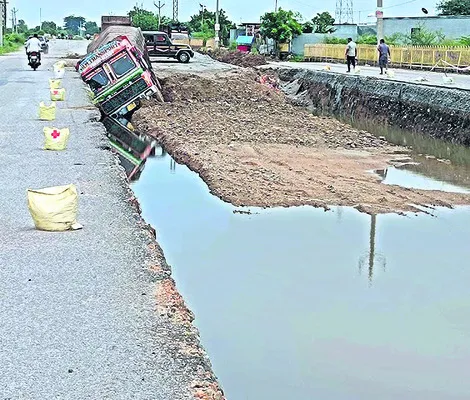గుంతలో పడిన లారీ.. డ్రైవర్‌కు గాయాలు