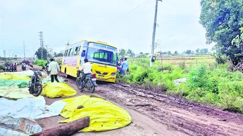 రోడ్డు నిండా ధాన్యం.. బురదలోకి స్కూల్‌ వాహనం
