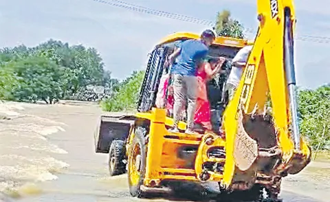 Brides cross a stream in a JCB