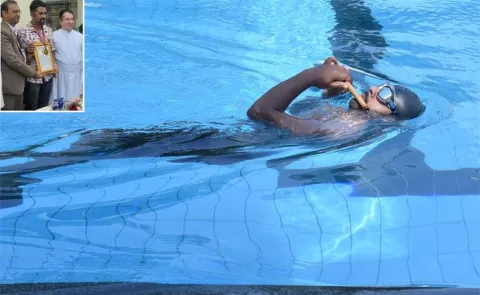 Young musician creates record by playing flute while swimming backstroke