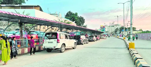నీడలో వాహనాలు.. ఎండలో భక్తులు