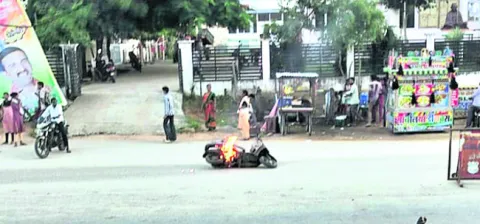 రోడ్డుకు తాకిన స్టాండ్‌రాడ్‌.. స్కూటీకి మంటలు

