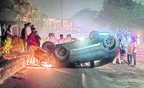 డివైడర్‌ను ఢీకొట్టి బోల్తాపడ్డ కారు 
