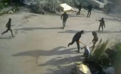 Armed men beating a Palestinian in the Israeli-occupied West Bank