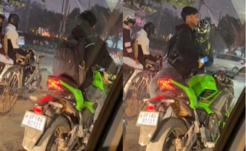 Biker pauses at traffic signal to let cyclist pose with his superbike