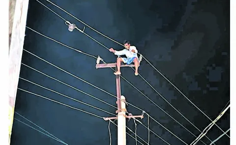 Drunk man climbs electric pole