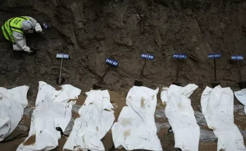 Officials conducting mass burials of bodies in Nepal
