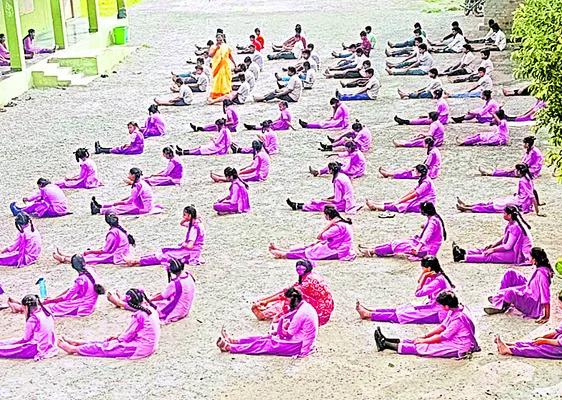 మండుటెండలో కటిక నేలపై విద్యార్థుల యోగాసనాలు