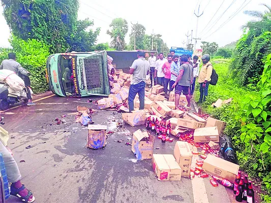 రహదారిపై మద్యం వాహనం బోల్తా