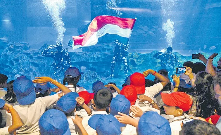 Chennai scuba diver displays India national flag at a marine aquarium