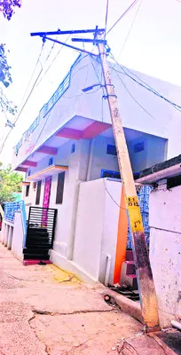 ఇళ్లపై కూలిన విద్యుత్ స్తంభాలు