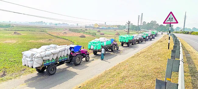 బారులు తీరిన ధాన్యం ట్రాక్టర్లు 
