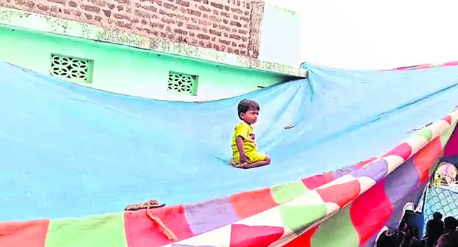 స్లాబ్‌ పైనుంచి టెంట్‌పైకి దొర్లిన రెండేళ్ల బాలుడు