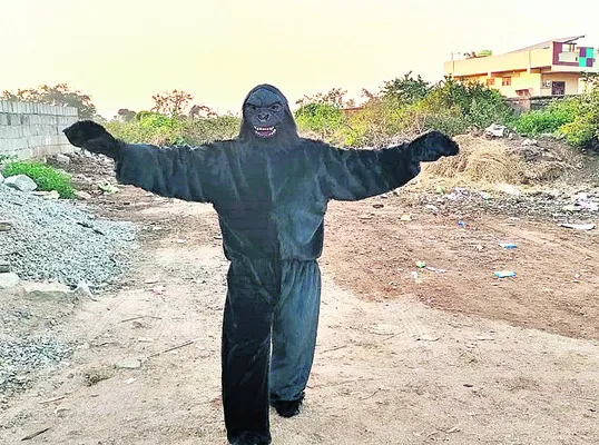 కోతులను తరిమిన  ఎలుగుబంటి వేషధారి
