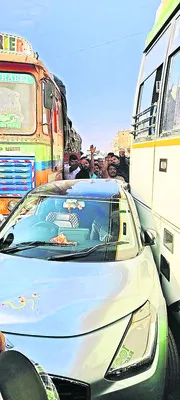 లారీ, బస్సు మధ్యలో చిక్కుకున్న కారు 
