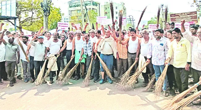 రోడ్లు ఊడ్చి పీఏసీఎస్‌ ఉద్యోగుల నిరసన 