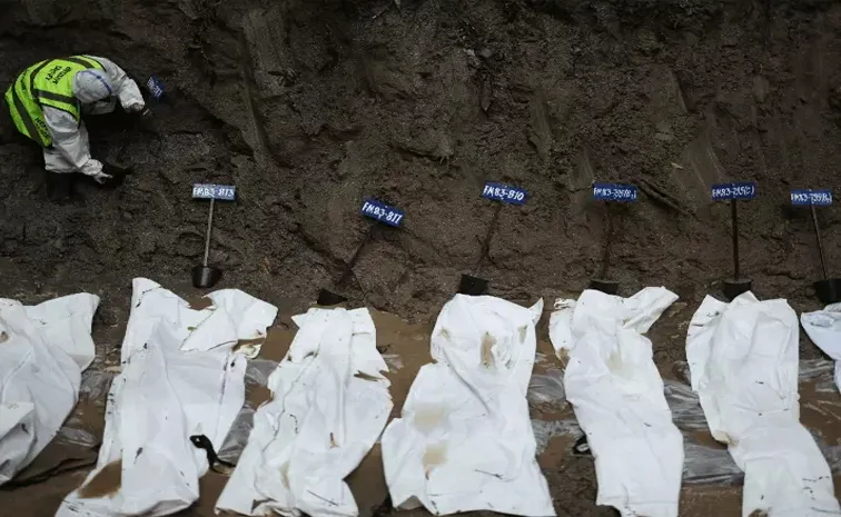 Officials conducting mass burials of bodies in Nepal